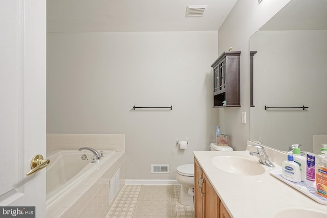 bathroom featuring vanity, a relaxing tiled tub, and toilet