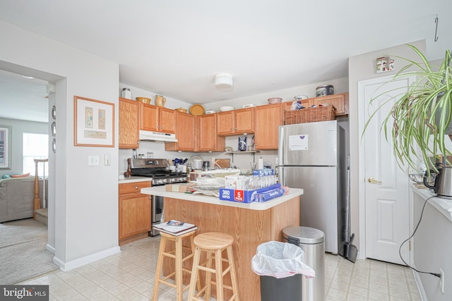 kitchen with appliances with stainless steel finishes, a kitchen island with sink, and a kitchen breakfast bar