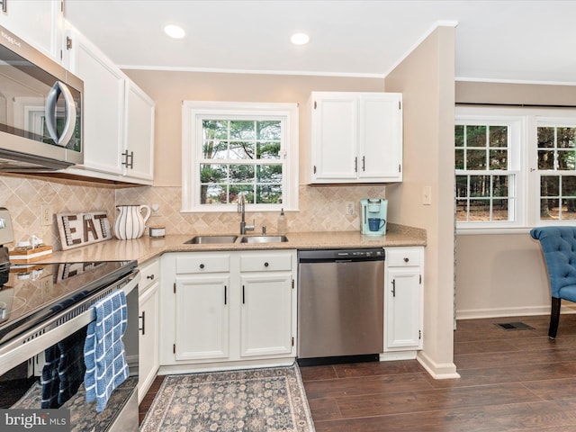 kitchen featuring white cabinetry, sink, tasteful backsplash, dark hardwood / wood-style flooring, and appliances with stainless steel finishes