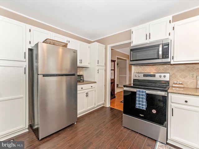 kitchen with tasteful backsplash, ornamental molding, stainless steel appliances, dark hardwood / wood-style floors, and white cabinetry