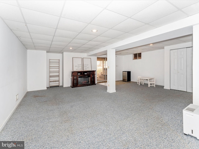 basement with carpet flooring and a drop ceiling