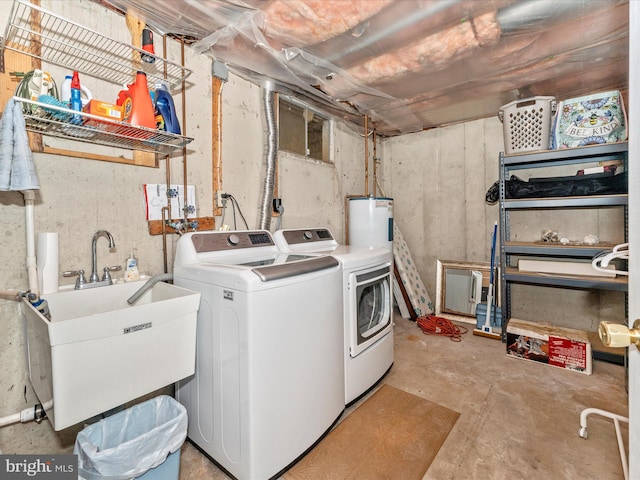 clothes washing area with water heater, sink, and washer and dryer