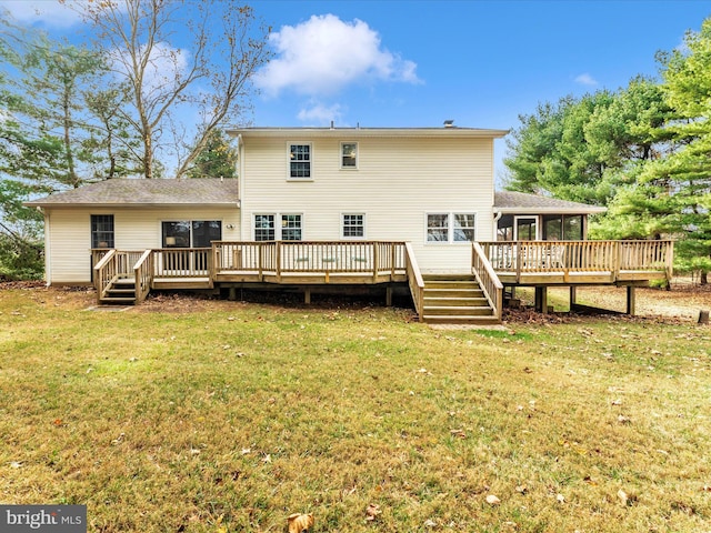 rear view of house with a wooden deck and a lawn