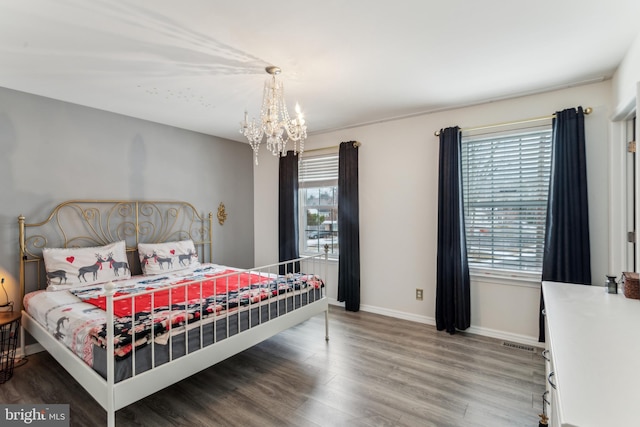 bedroom with hardwood / wood-style flooring and a notable chandelier