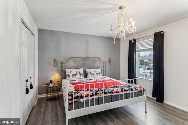 bedroom with a closet, hardwood / wood-style floors, and a notable chandelier