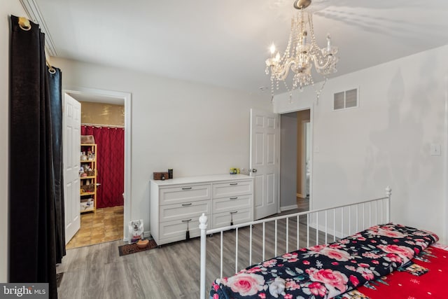 bedroom featuring hardwood / wood-style flooring and a notable chandelier