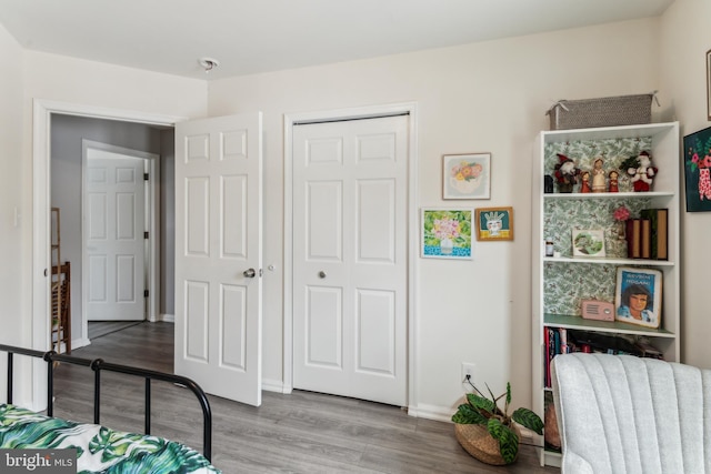 bedroom featuring radiator heating unit, a closet, and hardwood / wood-style flooring