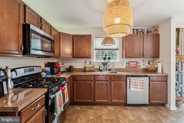 kitchen featuring appliances with stainless steel finishes, light stone counters, and sink