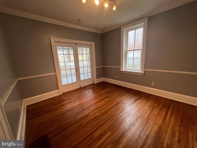 empty room featuring dark hardwood / wood-style floors, a wealth of natural light, and ornamental molding