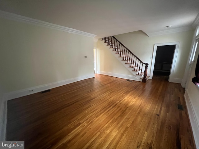 unfurnished living room featuring hardwood / wood-style floors and crown molding