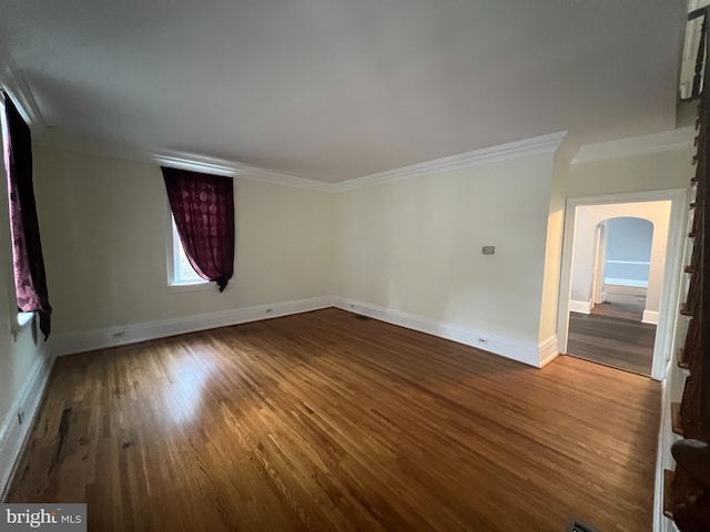 empty room with hardwood / wood-style flooring and ornamental molding