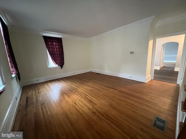 spare room with hardwood / wood-style flooring and crown molding