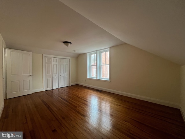 bonus room featuring vaulted ceiling and dark wood-type flooring