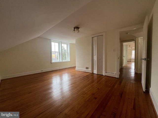 additional living space with lofted ceiling and dark hardwood / wood-style floors