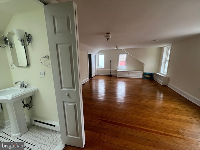 bonus room featuring hardwood / wood-style flooring, sink, and a baseboard heating unit