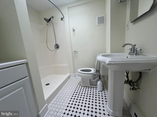 bathroom with a shower, toilet, and baseboard heating