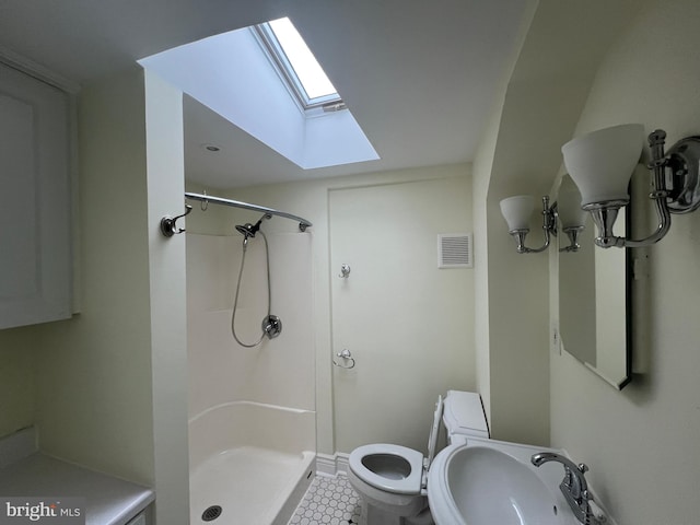 bathroom featuring a skylight, toilet, sink, and walk in shower