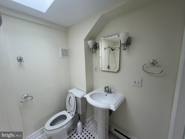 bathroom featuring toilet, sink, a baseboard radiator, and a skylight