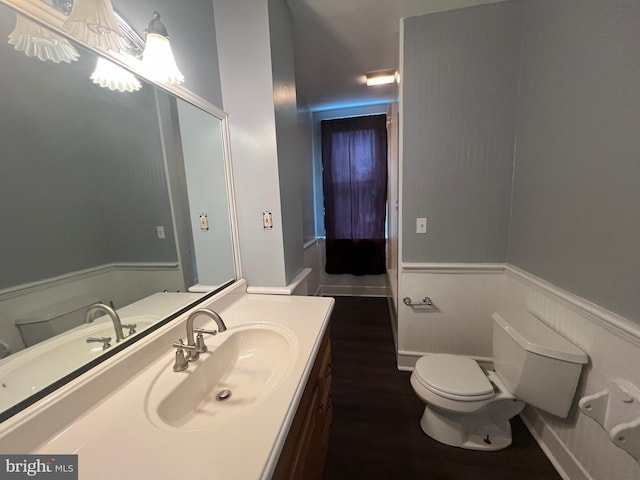 bathroom with hardwood / wood-style flooring, vanity, and toilet