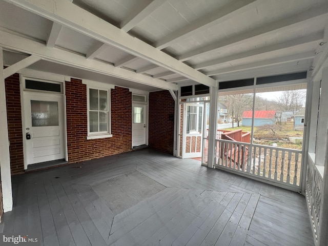 unfurnished sunroom with beamed ceiling