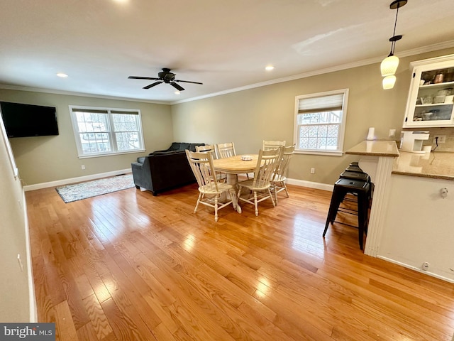 dining area featuring ornamental molding and light hardwood / wood-style floors