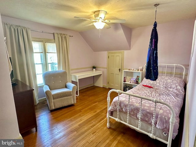 bedroom featuring ceiling fan, lofted ceiling, and wood-type flooring