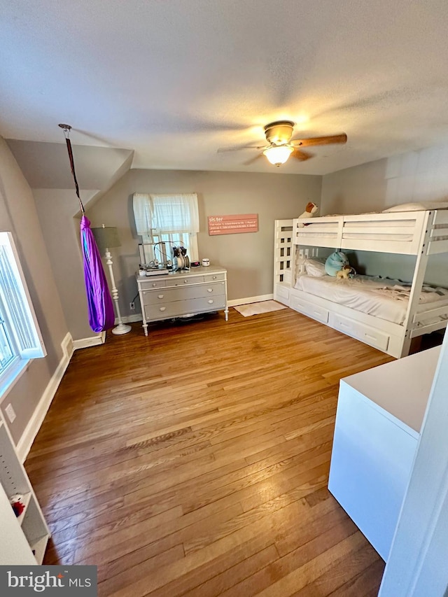 bedroom featuring wood-type flooring, ceiling fan, and a textured ceiling