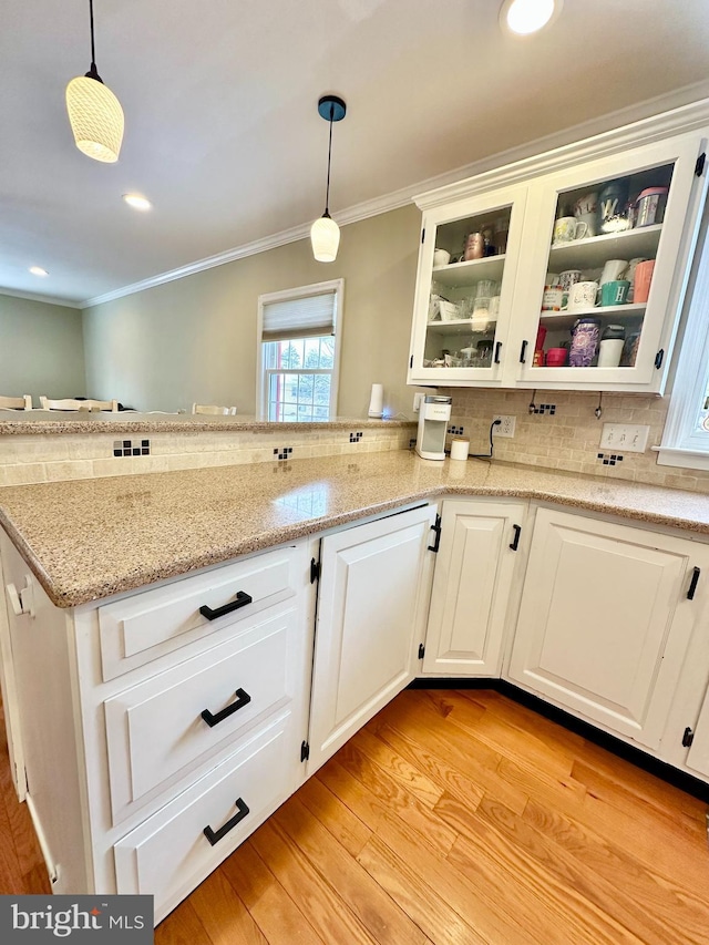 kitchen featuring crown molding, decorative light fixtures, and white cabinets