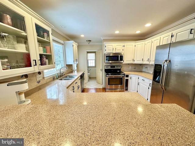 kitchen featuring white cabinetry, sink, decorative backsplash, and stainless steel appliances