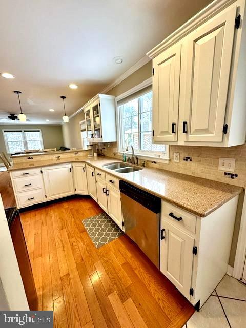 kitchen with white cabinetry, decorative light fixtures, dishwasher, and sink