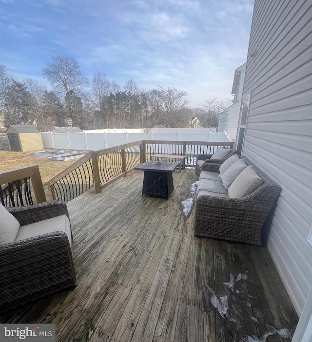 wooden deck featuring an outdoor living space with a fire pit