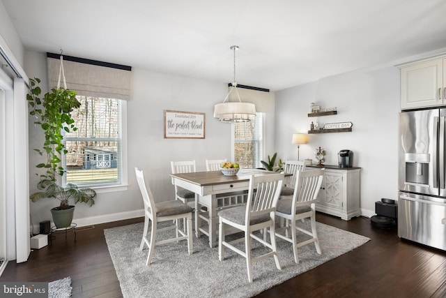 dining area featuring dark hardwood / wood-style floors and an inviting chandelier