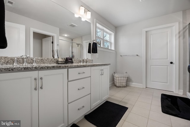 bathroom with tile patterned flooring, vanity, and an enclosed shower