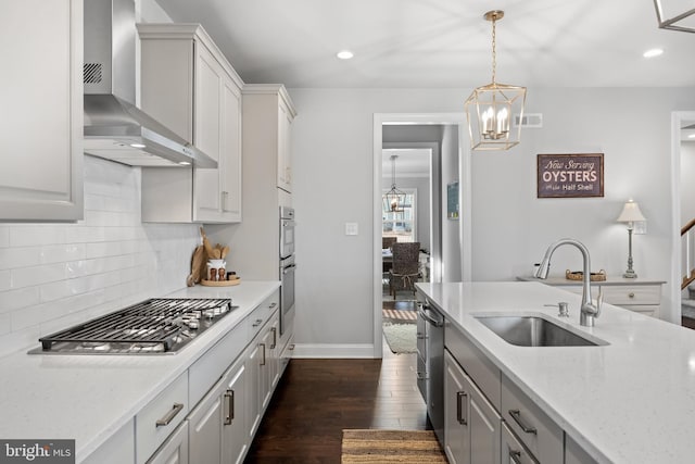 kitchen with light stone countertops, sink, wall chimney exhaust hood, stainless steel appliances, and dark hardwood / wood-style floors