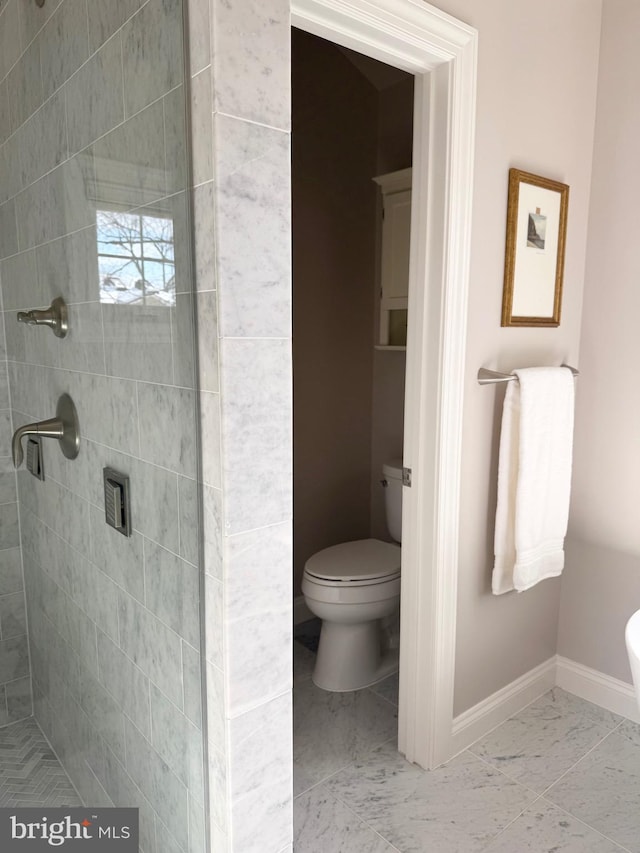 bathroom featuring toilet and a tile shower