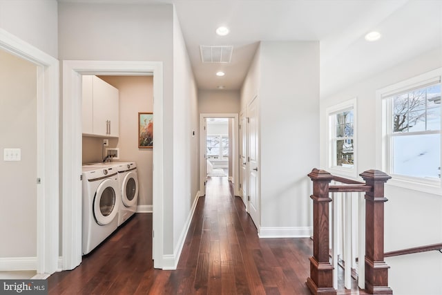 laundry room with washer and dryer, cabinets, and dark wood-type flooring