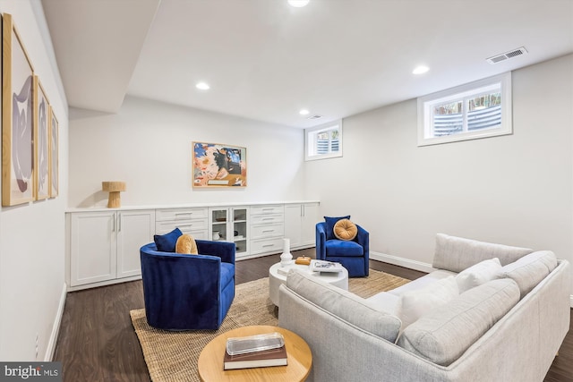 living room with plenty of natural light and dark wood-type flooring