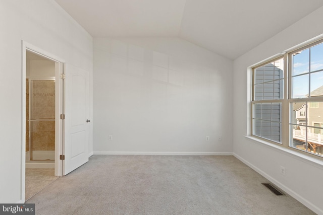 unfurnished room featuring light colored carpet and lofted ceiling