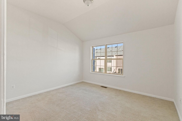 empty room with light carpet and lofted ceiling