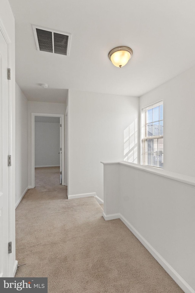 hall with light colored carpet