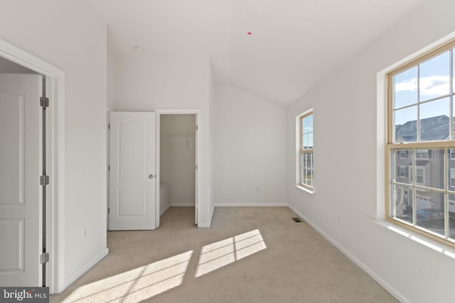 unfurnished bedroom with a mountain view, a closet, light colored carpet, and lofted ceiling