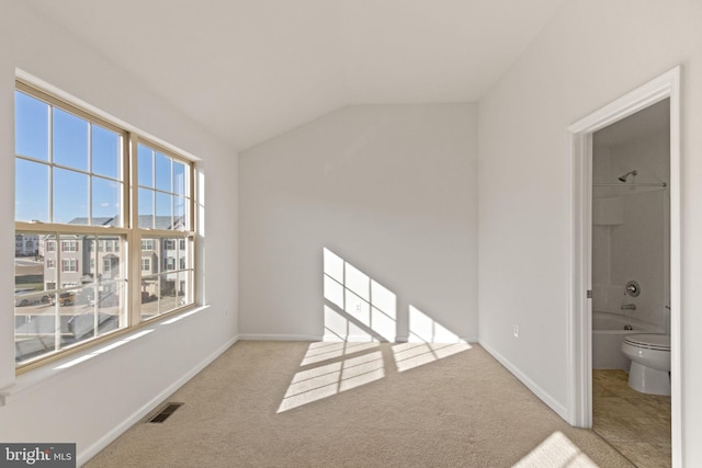 carpeted spare room featuring lofted ceiling