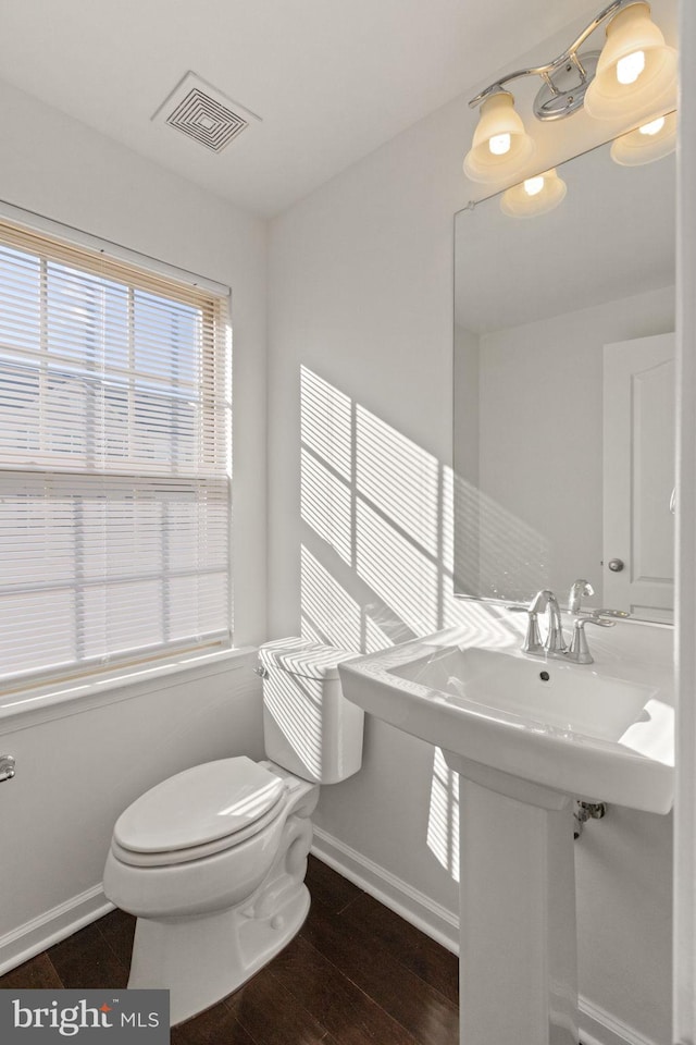 bathroom with hardwood / wood-style flooring and toilet