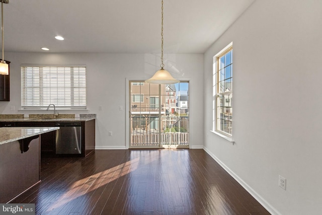 kitchen featuring stainless steel dishwasher, pendant lighting, sink, and a wealth of natural light