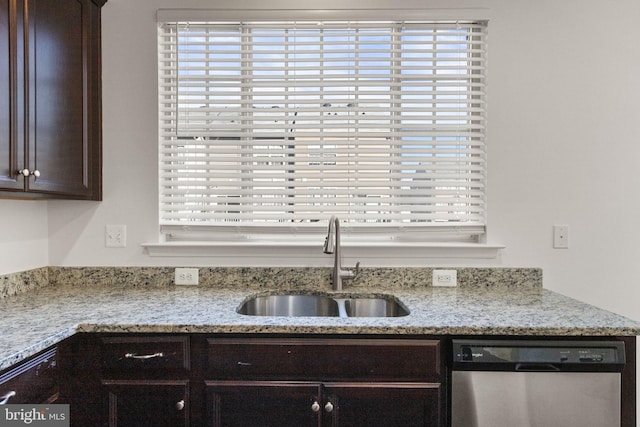 kitchen featuring light stone counters, sink, stainless steel dishwasher, and dark brown cabinets