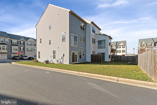 exterior space with a lawn and central AC