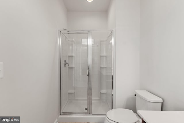 bathroom featuring toilet, an enclosed shower, and vanity