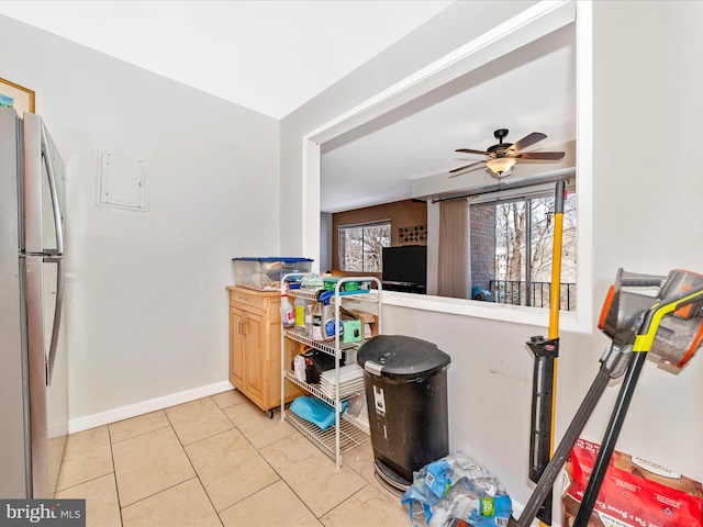 kitchen featuring stainless steel refrigerator, ceiling fan, light brown cabinetry, and light tile patterned floors