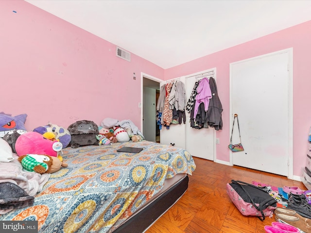 bedroom featuring parquet flooring and a closet