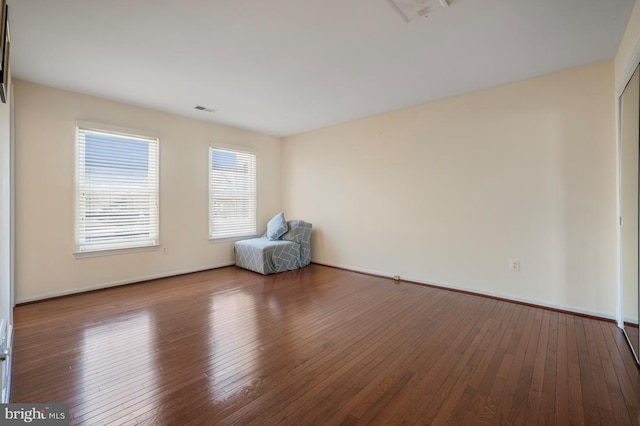 unfurnished room with wood-type flooring and visible vents